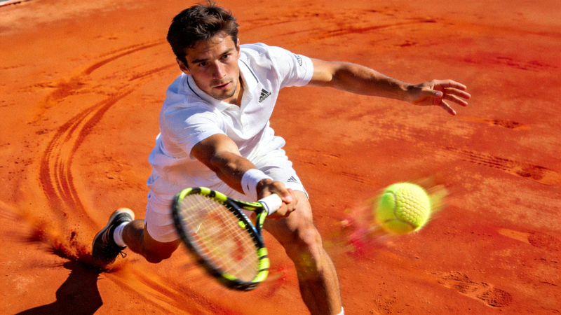 网球运动员在红土场上奋力挥拍击球